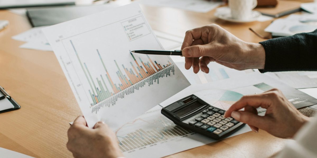 Individuals discuss financing options for a significant property purchase, reviewing paperwork.
