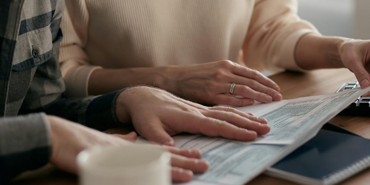 A couple reviewing financial documents and discussing their budget for a major investment.