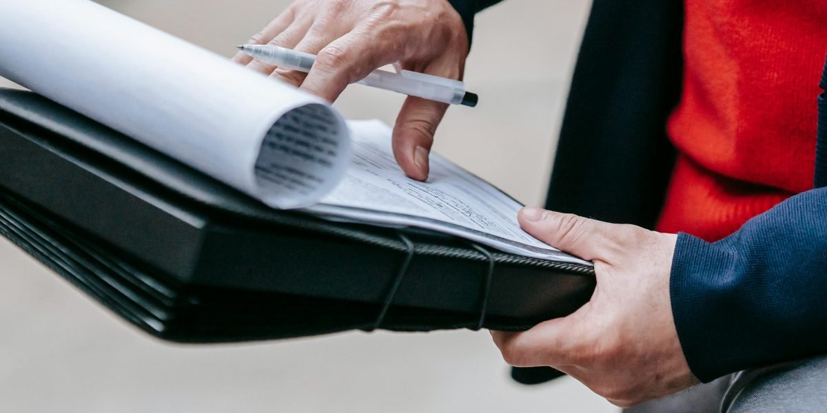 A person meticulously reviewing documents to avoid hidden costs and unverified listings.