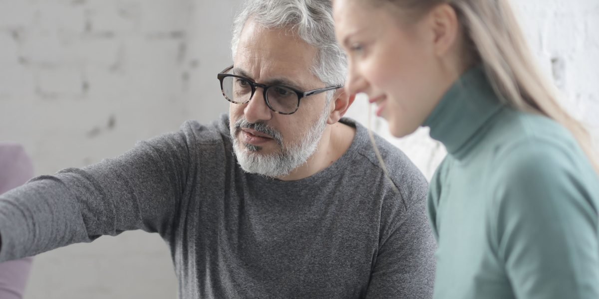 An experienced professional guiding a new team member, illustrating career progression and skill development in real estate.