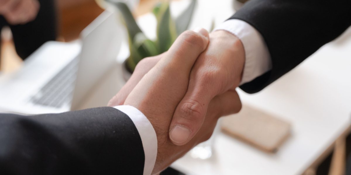 Business partners shaking hands, symbolizing a successful agreement with a chosen lender.