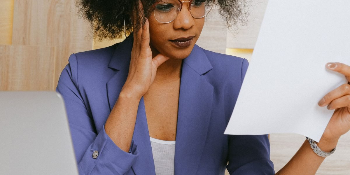 A person looking confused while reviewing complex documents, symbolizing the challenges of understanding commercial lease agreements without legal help.