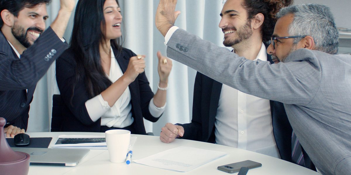 A team celebrating a successful outcome in a professional environment, symbolizing the positive results of proactive legal counsel in commercial real estate.