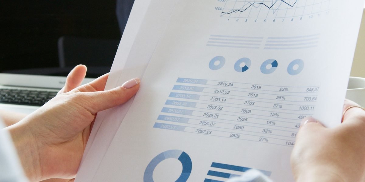 Professionals carefully reviewing various financial reports to compare lender offers and terms.