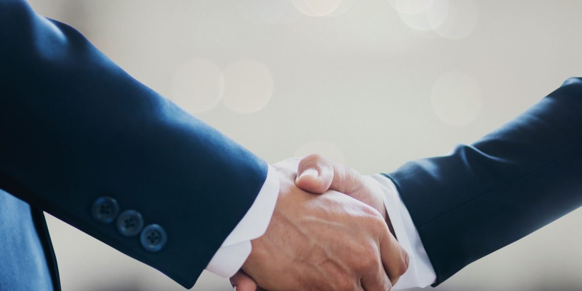 A professional handshake symbolizes trust and successful collaboration between clients and real estate agents.