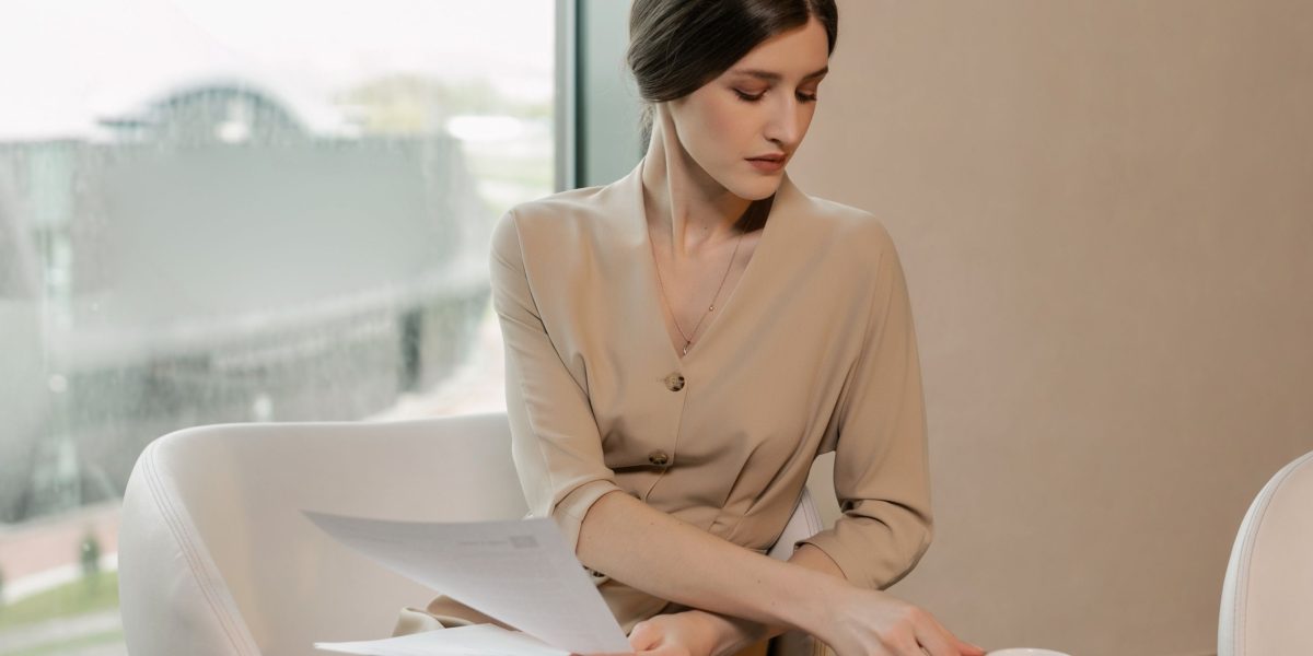 A person intently reviewing property documents at a coffee shop, emphasizing the importance of thorough research.