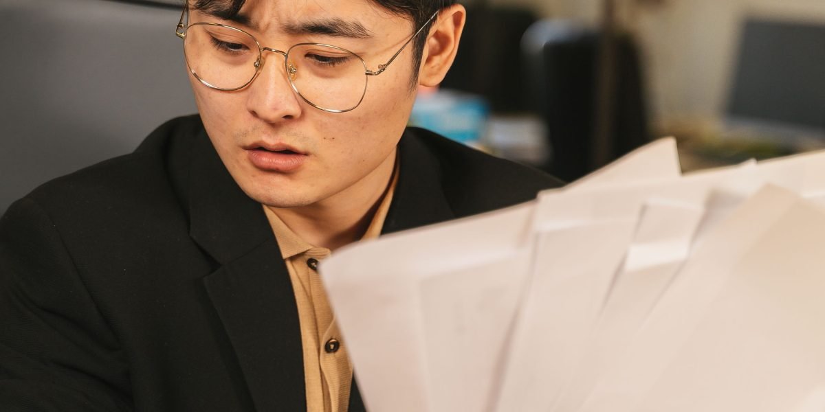 An individual carefully reviewing documents, seeking clarity in a complex market.