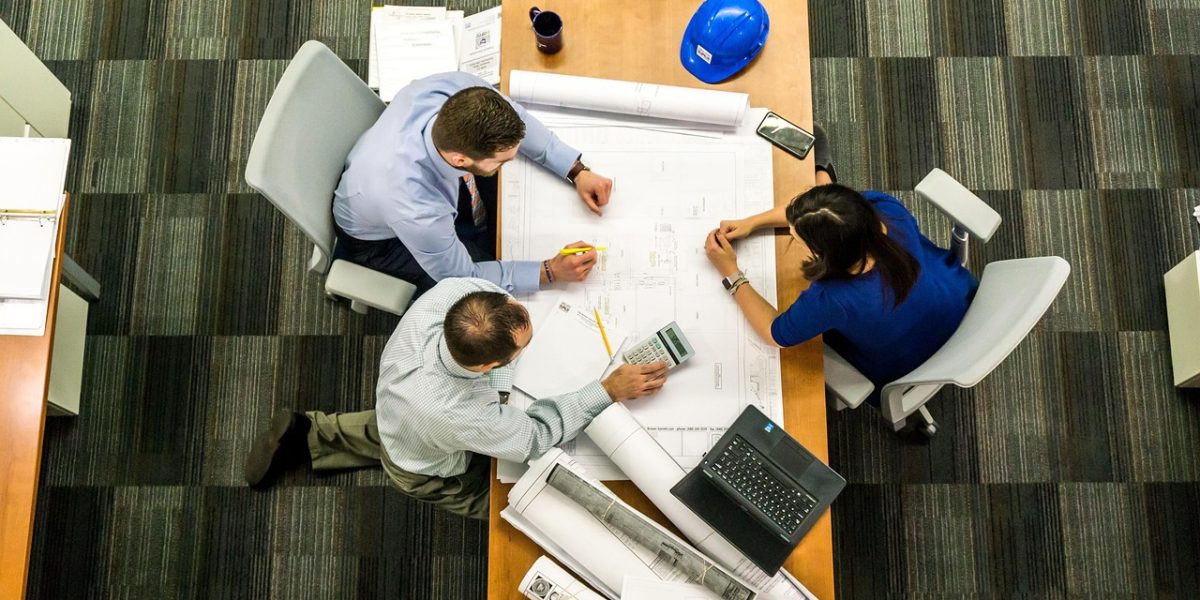 Professionals engaged in a detailed discussion, likely strategizing on commercial property investments.