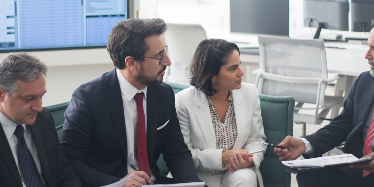 Executives collaborating and discussing current market trends in a professional setting.