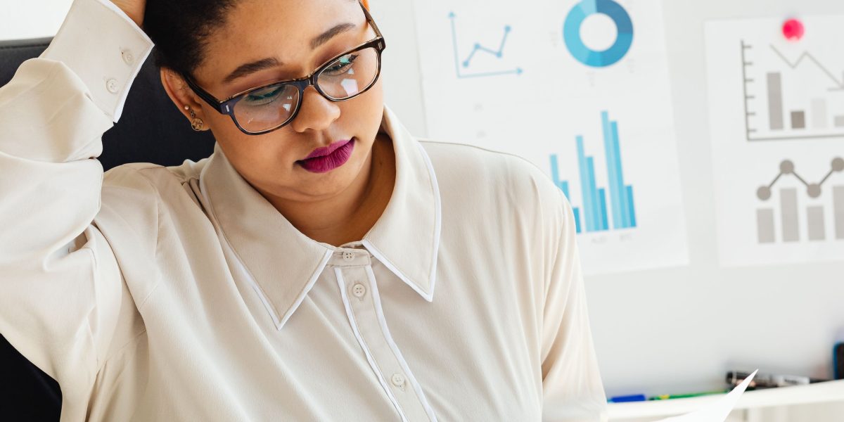 A professional contemplating financial documents, symbolizing the thought process behind commercial real estate investment.