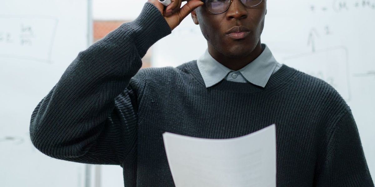 A person thoughtfully reviewing documents, symbolizing the process of simplifying complex financial information.