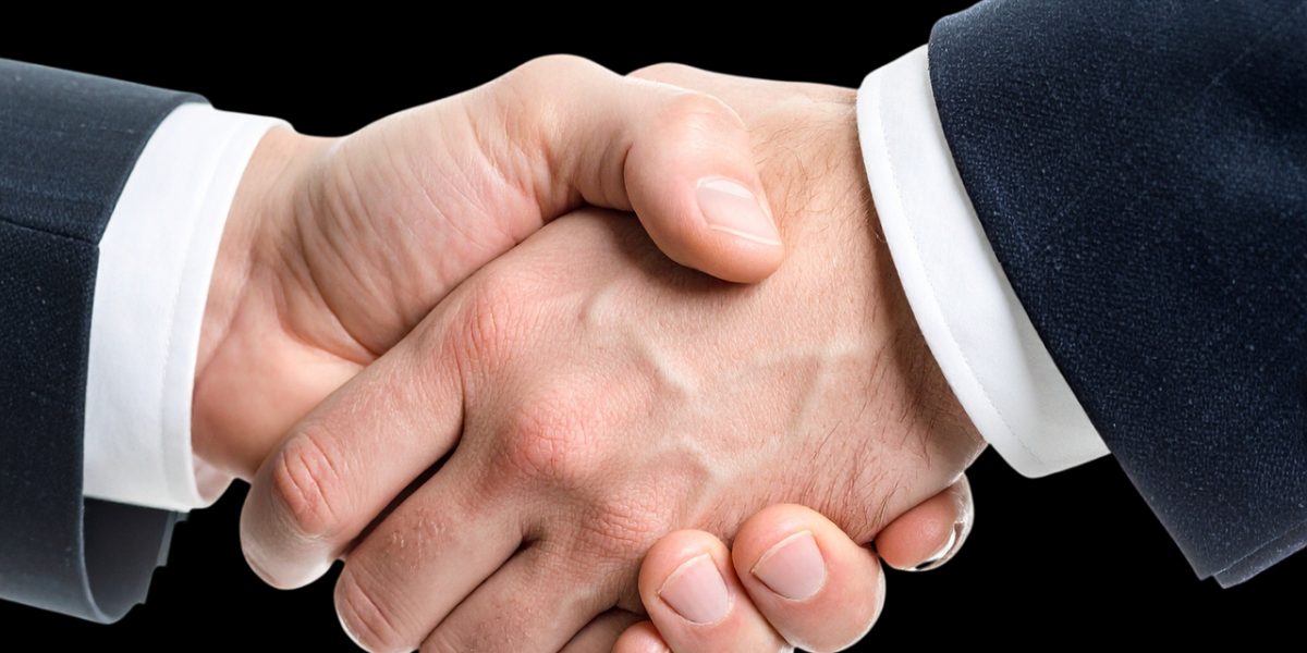 Two professionals shaking hands, signifying a successful agreement or negotiation in a business context.